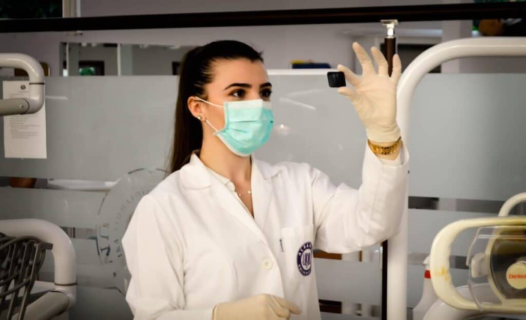 Medicial professional in hospital wearing a mask and examining a slide
