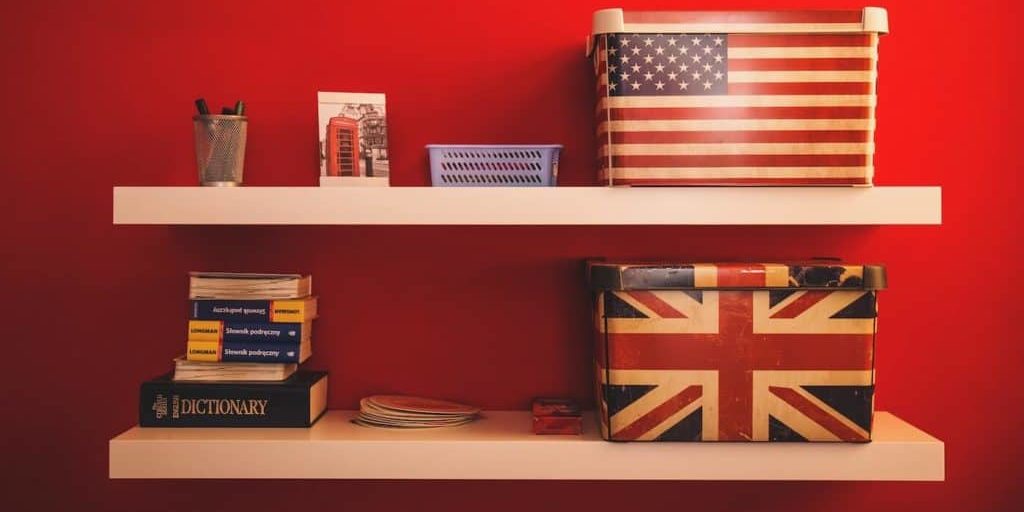 Shelf with UK and US flag boxes on it and a dictionary