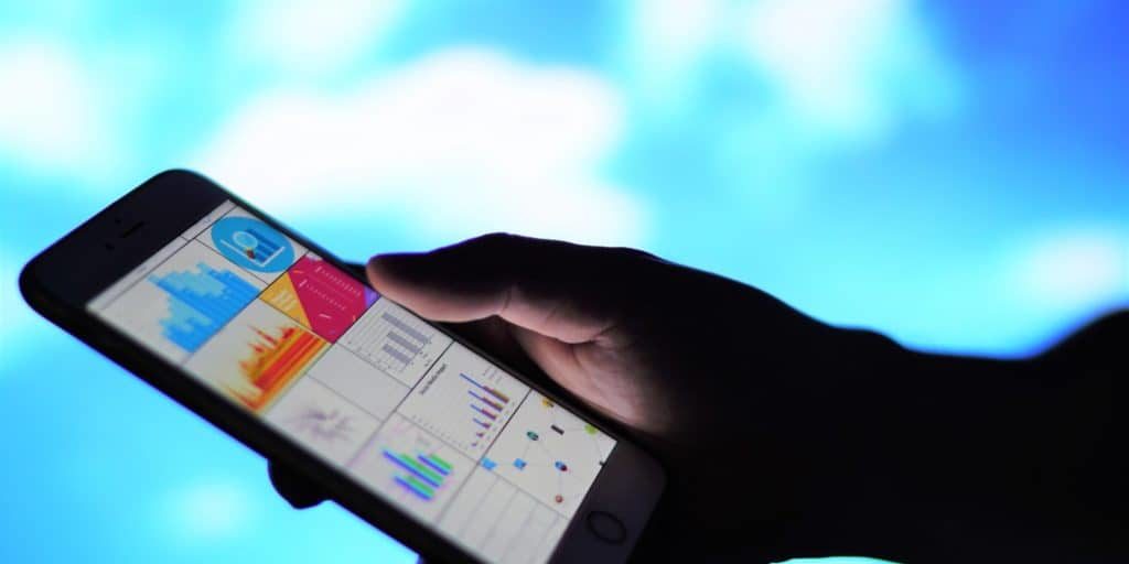 close-up-on-hand-holding-smartphone-showing-graphs-and-charts-on-screen-with-blurred-background_t20_NGpy3p Market Research Tools for 2020